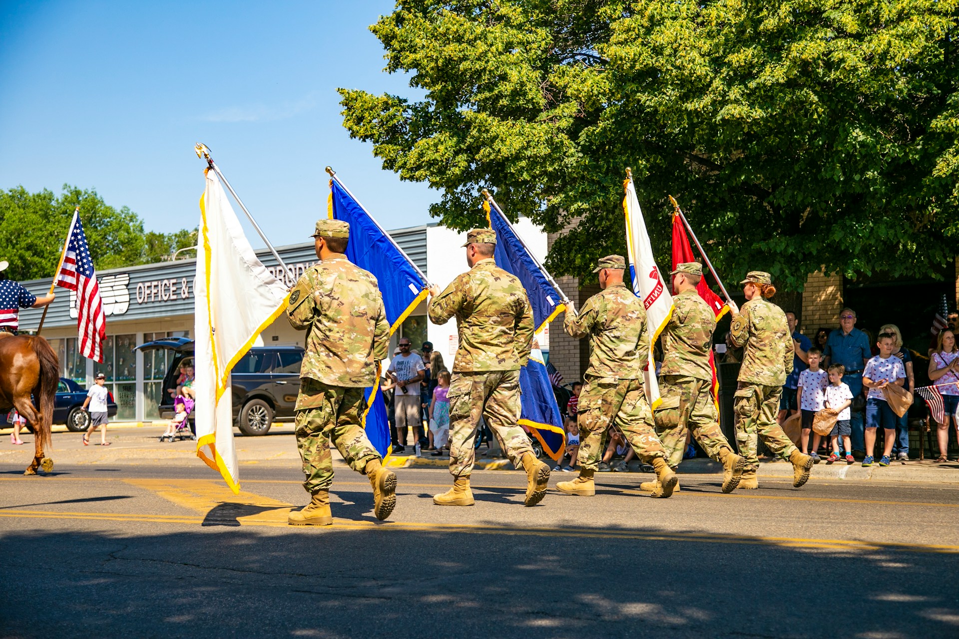 Military Service members carry flags during a parade in Miles City, Montana