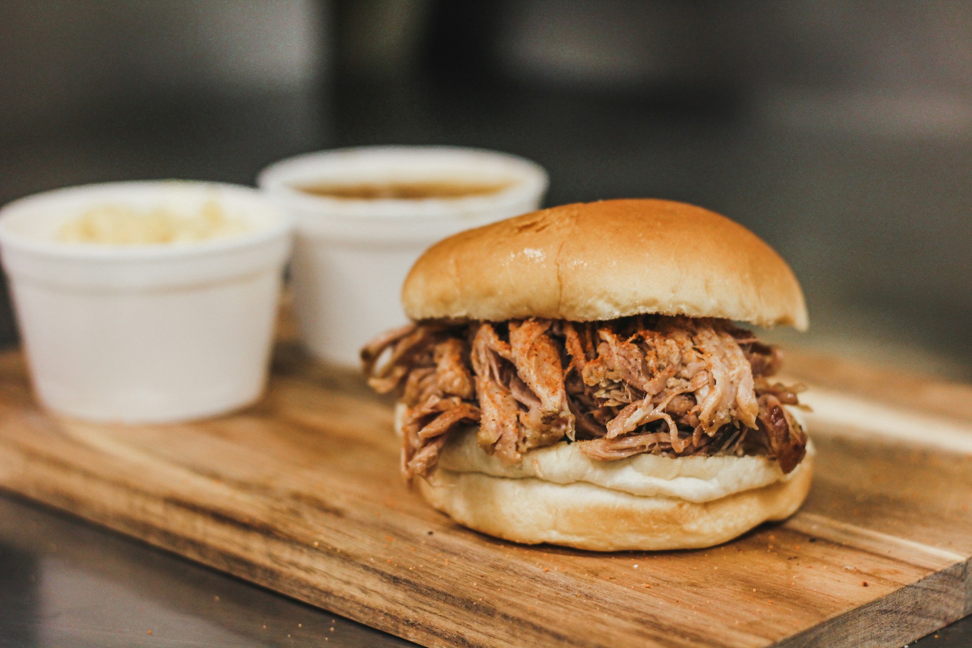 pulled pork sandwich on a wooden cutting board