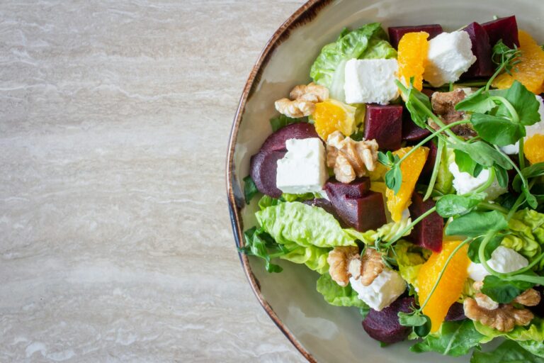 bowl full of salad with feta, beetroot, orange, walnut and leaves
