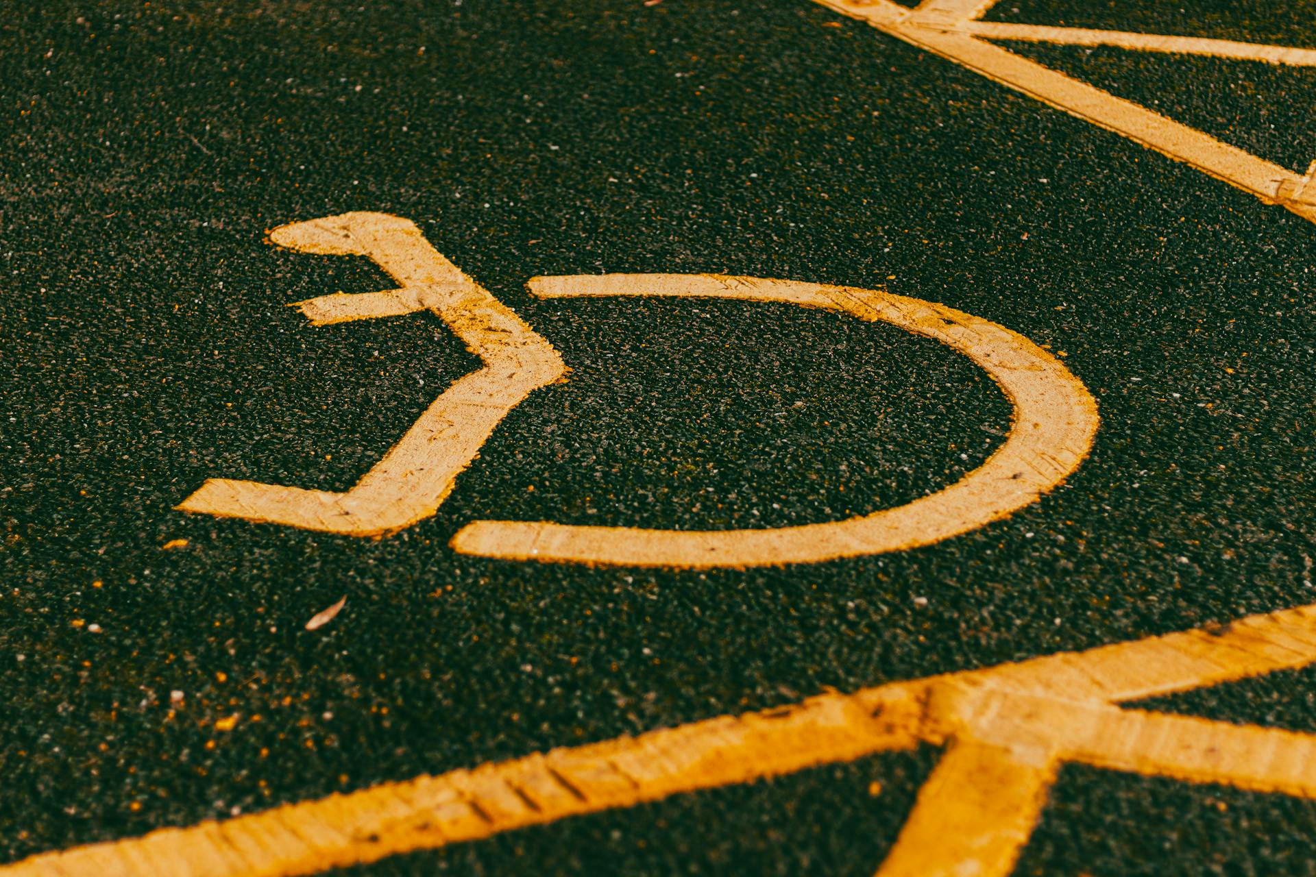 A Close-Up Shot of a Disabled Sign in Asphalt